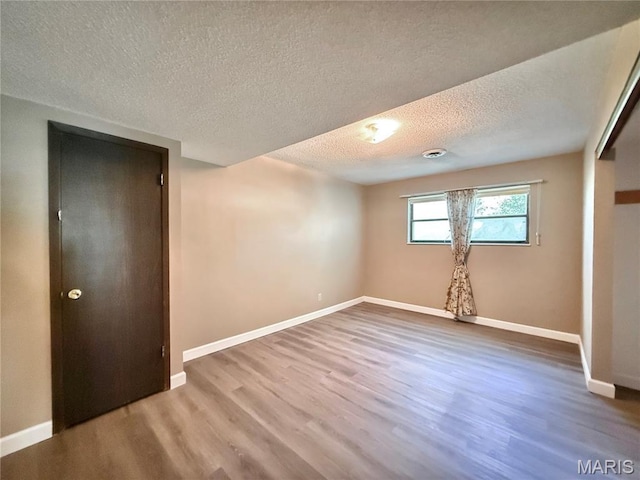 8305 Brouk Dr, Cedar Hill, MO 63016 - unfurnished bedroom with wood finished floors, a textured ceiling, baseboards, and a closet