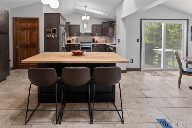 7 Tall Oaks Dr, Troy, IL 62294 - kitchen with vaulted ceiling, wooden counters, dark brown cabinetry, appliances with stainless steel finishes, and a breakfast bar area