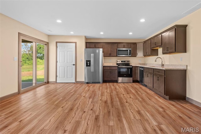 2805 Beth Ann Ct, Pontoon Beach, IL 62040 - kitchen featuring appliances with stainless steel finishes, a sink, light wood-style flooring, dark brown cabinetry, and baseboards