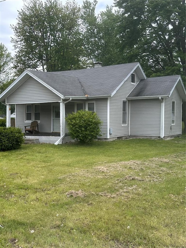 605 N Locust St, Monroe City, MO 63456 - view of front facade featuring covered porch, a front yard, a chimney, and roof with shingles