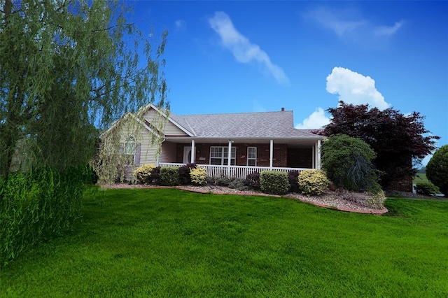 ranch-style house featuring a front yard, covered porch, and brick siding