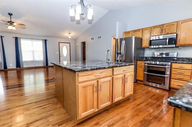 kitchen with appliances with stainless steel finishes, light wood-style flooring, a sink, ceiling fan, and lofted ceiling