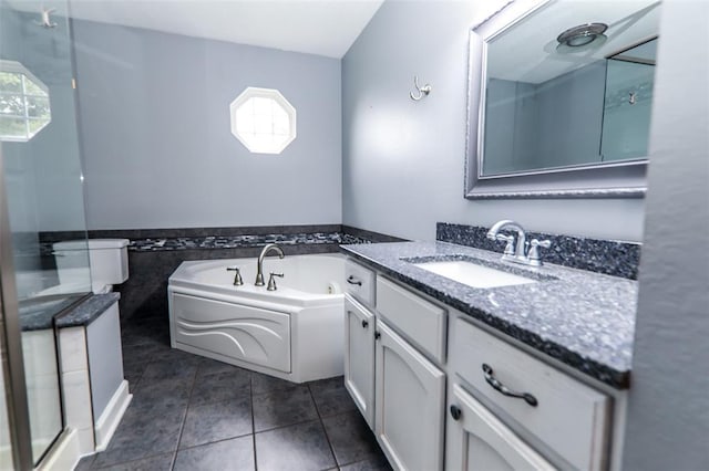 bathroom with healthy amount of natural light, vanity, tile patterned flooring, a bath, and wainscoting