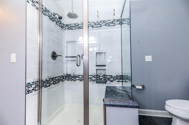full bath featuring a shower stall, toilet, and baseboards