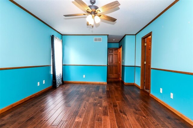 empty room with ornamental molding, a ceiling fan, wood finished floors, and baseboards