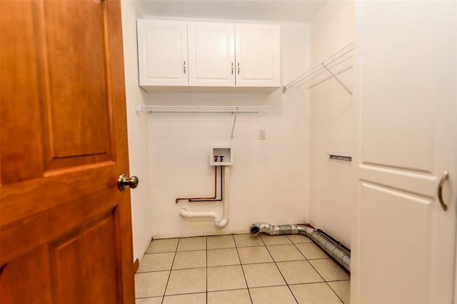 washroom featuring cabinet space, light tile patterned floors, and washer hookup