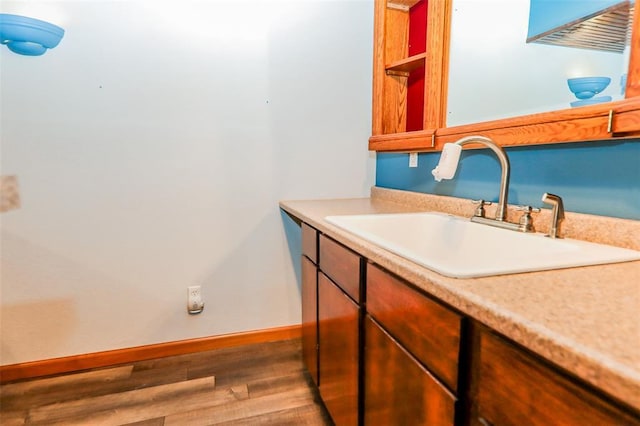 bathroom with wood finished floors, baseboards, and vanity