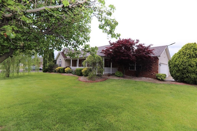 view of property hidden behind natural elements with a front lawn, a garage, and brick siding