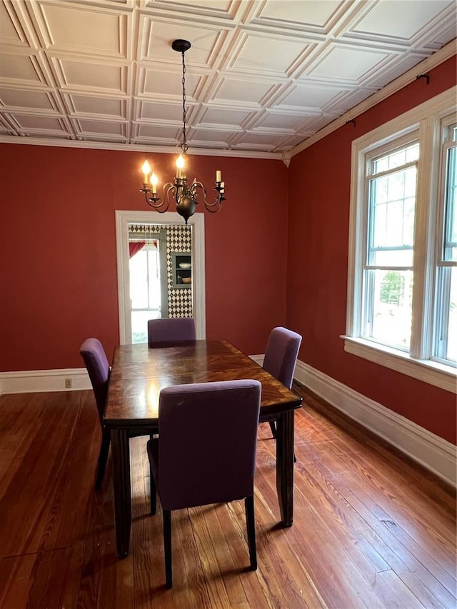 dining space with baseboards, a chandelier, healthy amount of natural light, and an ornate ceiling