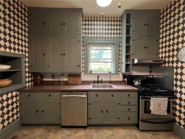kitchen with appliances with stainless steel finishes, open shelves, a sink, under cabinet range hood, and wallpapered walls