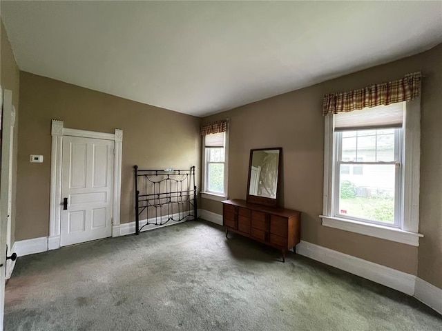 unfurnished room with carpet floors and baseboards