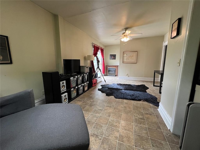 living room with a ceiling fan and baseboards