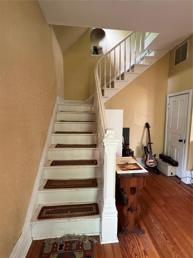 stairs featuring wood finished floors
