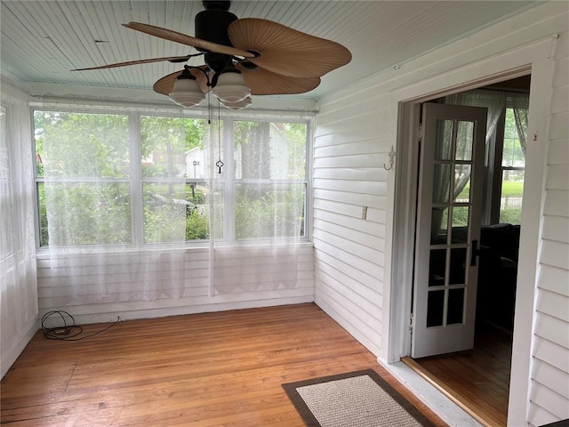 unfurnished sunroom featuring a ceiling fan