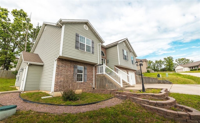 23529 Restore Rd, Waynesville, MO 65583 - view of home's exterior with driveway, a garage, brick siding, and a lawn