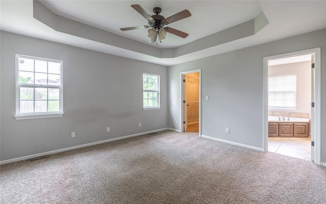 23529 Restore Rd, Waynesville, MO 65583 - unfurnished bedroom featuring light carpet, a raised ceiling, baseboards, a spacious closet, and connected bathroom