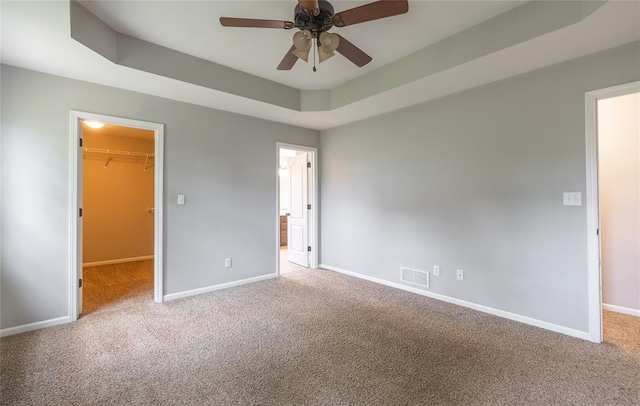 23529 Restore Rd, Waynesville, MO 65583 - unfurnished bedroom featuring carpet, a spacious closet, baseboards, a tray ceiling, and a closet