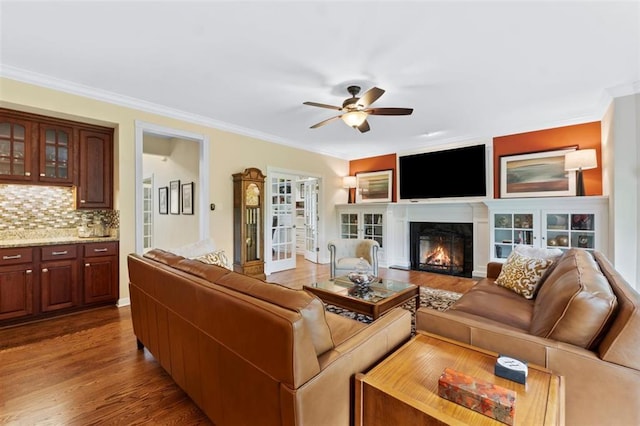 230 Merlot Ln, Saint Albans, MO 63073 - living area featuring a ceiling fan, wood finished floors, ornamental molding, and a lit fireplace