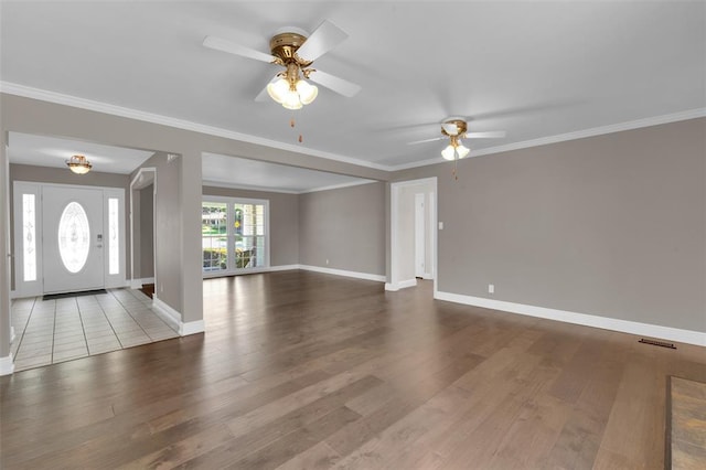 entrance foyer with a ceiling fan, wood finished floors, baseboards, and crown molding