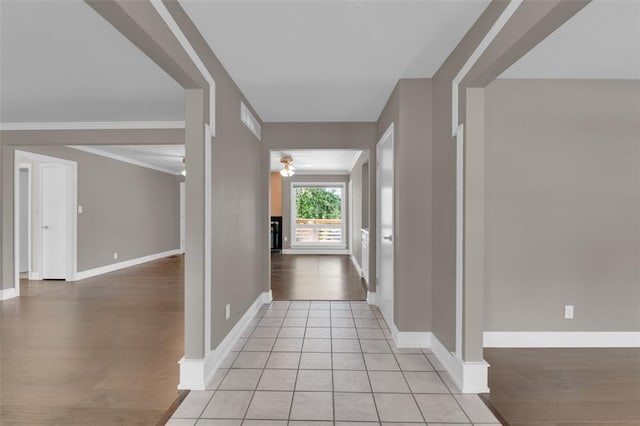 corridor featuring light wood-style flooring and baseboards