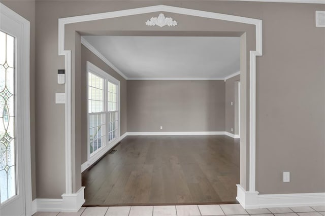 foyer entrance featuring wood finished floors, baseboards, and crown molding