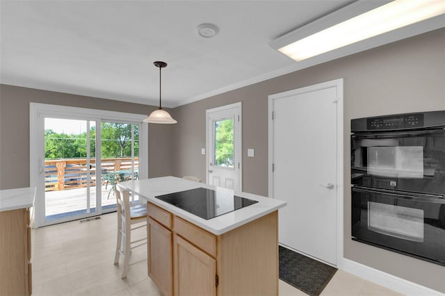 kitchen featuring black appliances, light brown cabinets, light countertops, a kitchen island, and crown molding