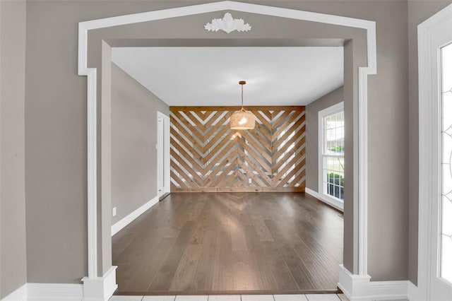 unfurnished dining area featuring wood finished floors and baseboards
