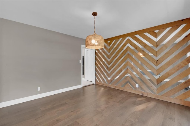 spare room featuring baseboards and dark wood-style flooring