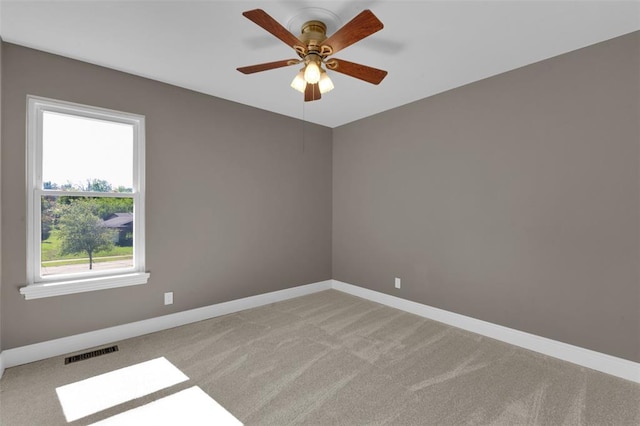 spare room with light carpet, baseboards, and ceiling fan
