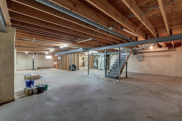 below grade area with stairway, electric water heater, and heating unit