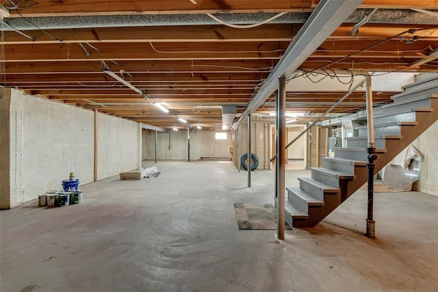 unfinished basement with stairway and gas water heater