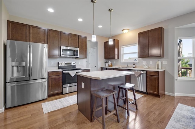 1051 Timber Creek Ln, Imperial, MO 63052 - kitchen with stainless steel appliances, a center island, dark brown cabinetry, light wood-type flooring, and recessed lighting