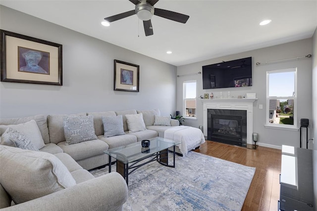 1051 Timber Creek Ln, Imperial, MO 63052 - living room featuring a ceiling fan, wood finished floors, recessed lighting, a glass covered fireplace, and baseboards