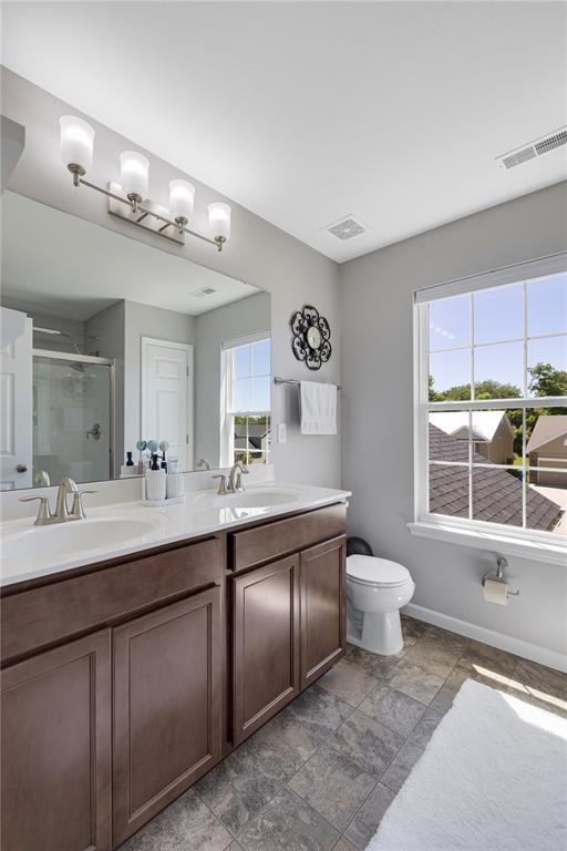 1051 Timber Creek Ln, Imperial, MO 63052 - full bathroom with a shower stall, plenty of natural light, double vanity, and toilet