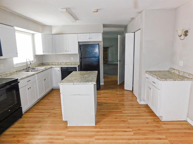 kitchen featuring a sink, black appliances, a center island, and light wood-style floors