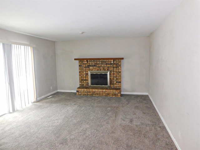 unfurnished living room featuring carpet floors, a fireplace, and baseboards