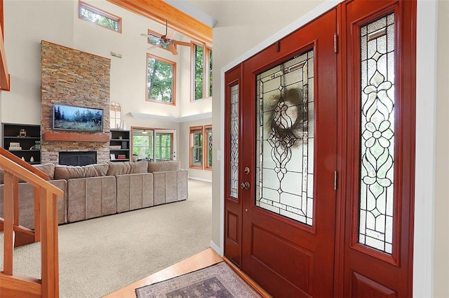 19072 Bear Trail Rd, Glencoe, MO 63038 - entrance foyer with a stone fireplace, a ceiling fan, a towering ceiling, wood finished floors, and baseboards