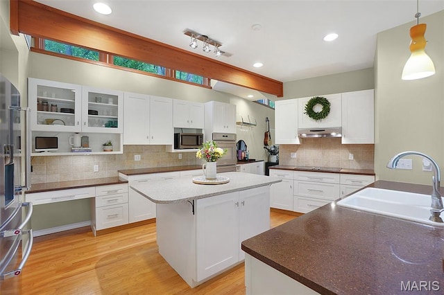 19072 Bear Trail Rd, Glencoe, MO 63038 - kitchen featuring black electric cooktop, stainless steel microwave, a center island, decorative backsplash, and high quality fridge