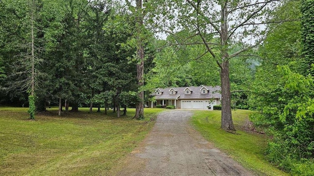 189 County Road 657, Cape Girardeau, MO 63701 - cape cod house featuring driveway, a front yard, an attached garage, and a view of trees