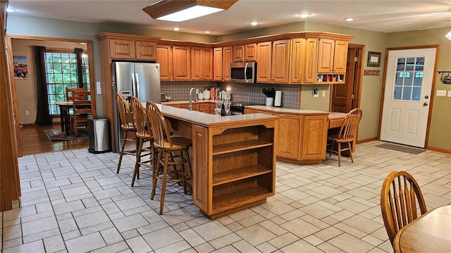 189 County Road 657, Cape Girardeau, MO 63701 - kitchen with appliances with stainless steel finishes, open shelves, tasteful backsplash, light countertops, and recessed lighting