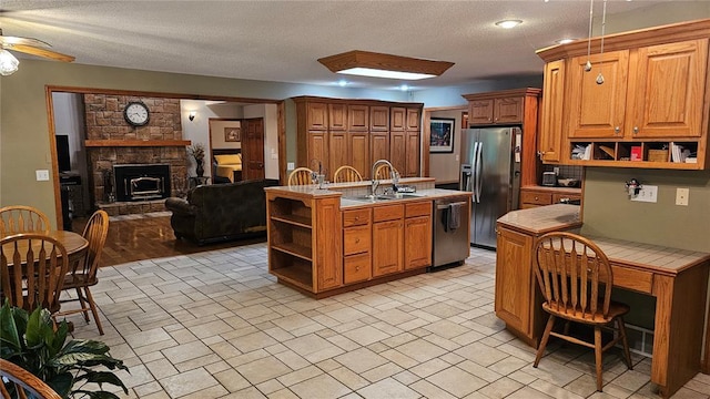 189 County Road 657, Cape Girardeau, MO 63701 - kitchen with open shelves, appliances with stainless steel finishes, a sink, tile countertops, and a textured ceiling