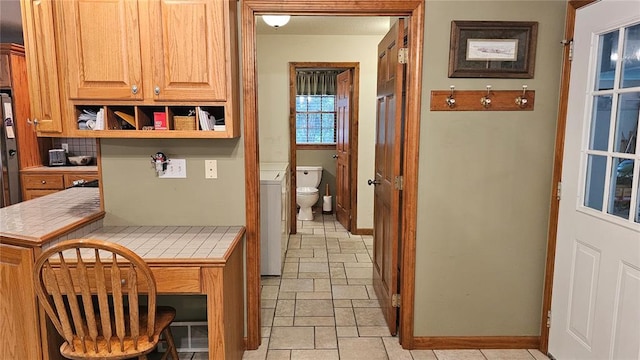 189 County Road 657, Cape Girardeau, MO 63701 - kitchen featuring tile countertops, baseboards, stone tile flooring, open shelves, and washer / dryer