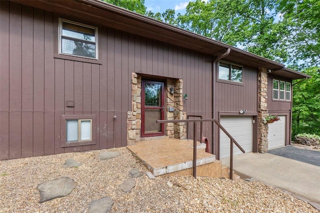 property entrance with asphalt driveway and an attached garage