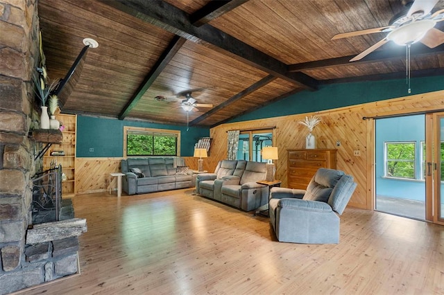 living area with a ceiling fan, wood walls, wooden ceiling, wood finished floors, and a wainscoted wall