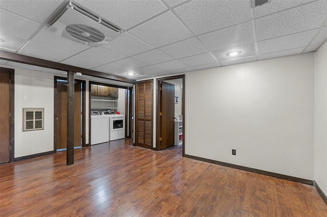 finished below grade area with independent washer and dryer, baseboards, wood finished floors, and a paneled ceiling