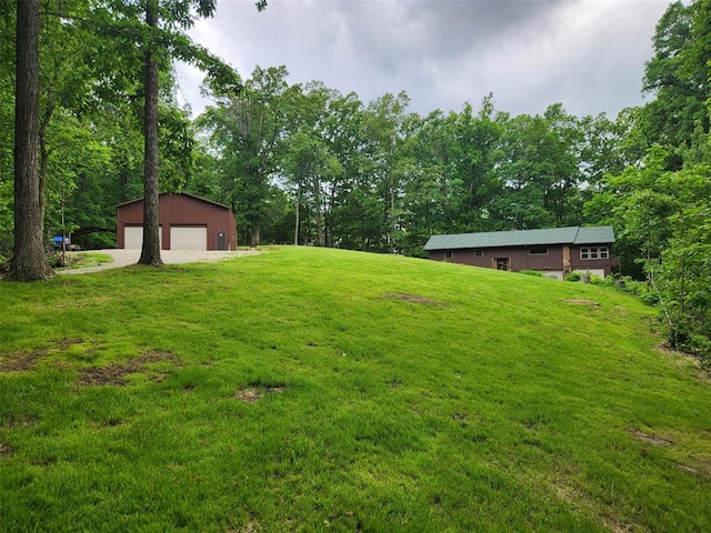 view of grassy yard featuring a garage and an outbuilding