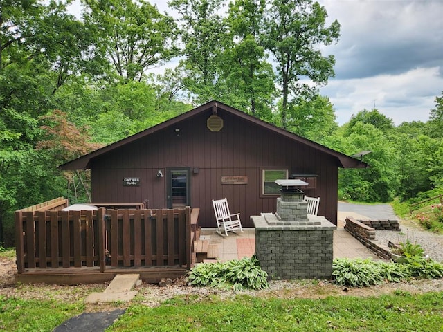 back of property with a deck and a wooded view
