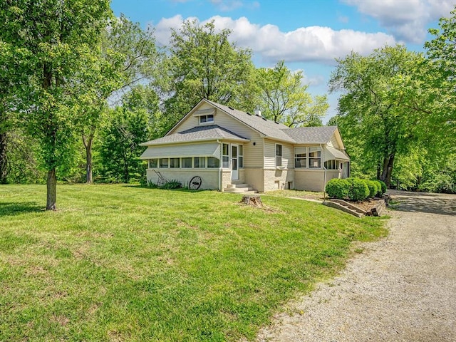 view of front of property with a front yard, entry steps, a shingled roof, and brick siding
