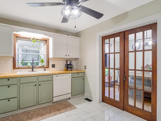 kitchen with dishwasher, green cabinets, wood counters, and a sink