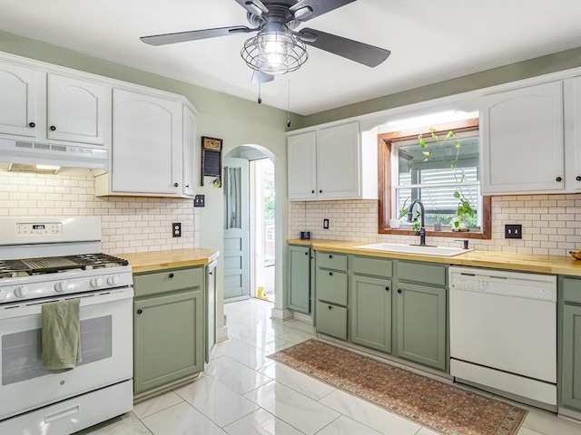 kitchen featuring white appliances, green cabinets, butcher block countertops, and under cabinet range hood